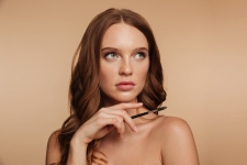 beauty-portrait-mystery-ginger-woman-with-long-hair-looking-away-while-holding-cosmetics-brush.jpg